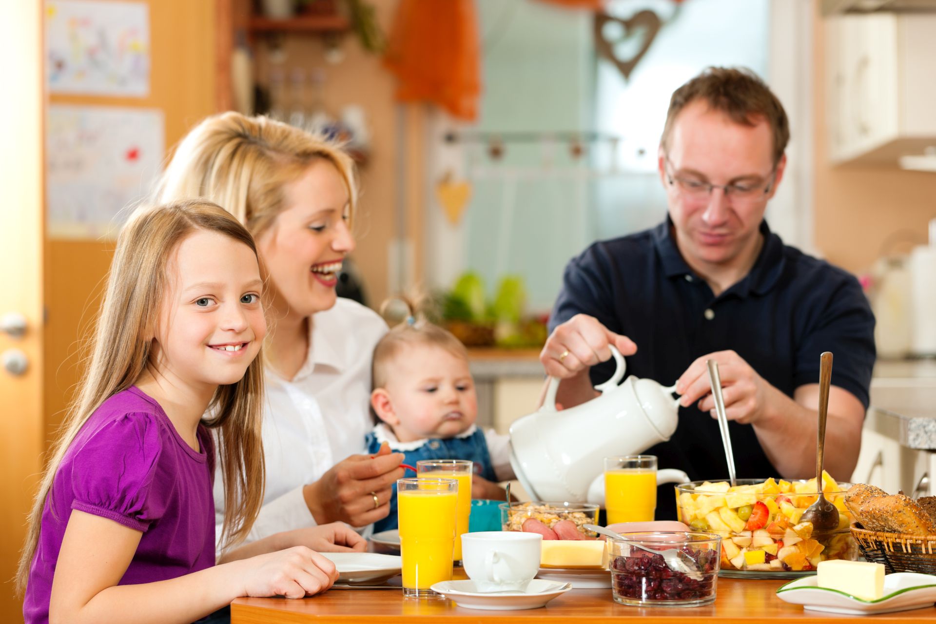 Familie gemeinsam am fruehstuecken.