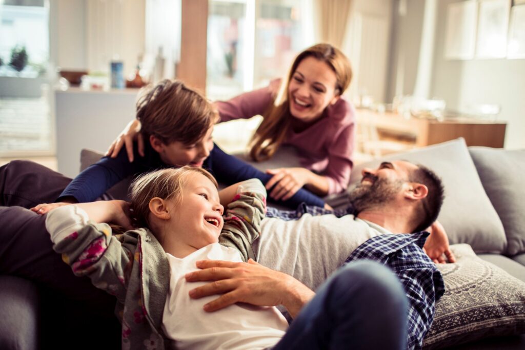 Familie entspannt gemeinsam auf der Couch.